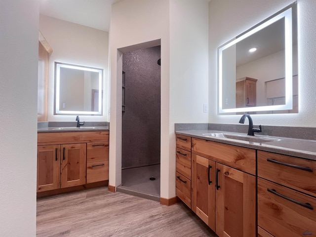 bathroom featuring a shower, vanity, and hardwood / wood-style flooring