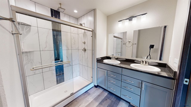 bathroom featuring wood-type flooring, a shower with shower door, and vanity