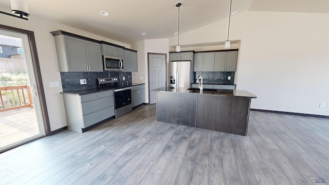 kitchen featuring sink, gray cabinetry, a center island with sink, pendant lighting, and stainless steel appliances