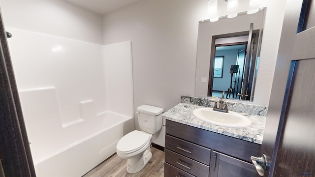 full bathroom featuring hardwood / wood-style floors, vanity, shower / bath combination, and toilet