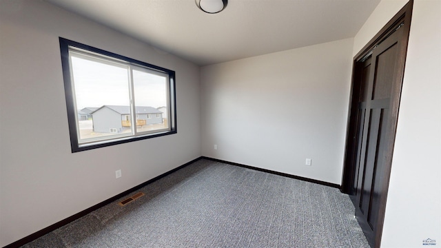 unfurnished bedroom featuring dark carpet