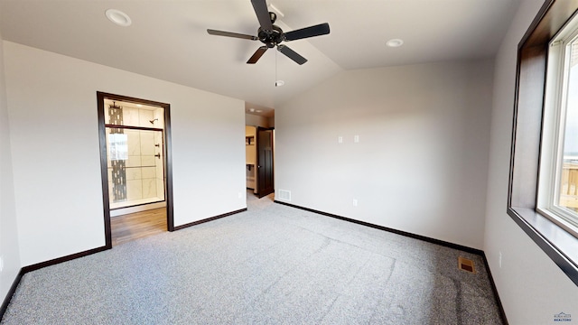 unfurnished bedroom with multiple windows, ceiling fan, light colored carpet, and lofted ceiling