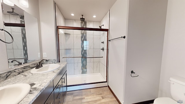 bathroom featuring vanity, toilet, wood-type flooring, and walk in shower