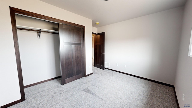 unfurnished bedroom featuring light carpet and a closet