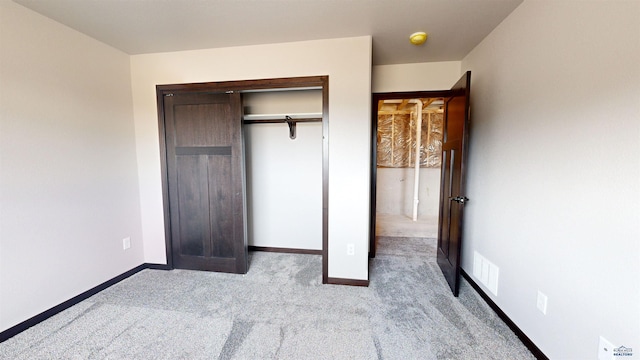 unfurnished bedroom featuring light colored carpet and a closet