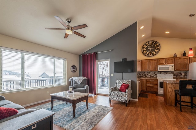 living room featuring ceiling fan, plenty of natural light, wood-type flooring, and lofted ceiling