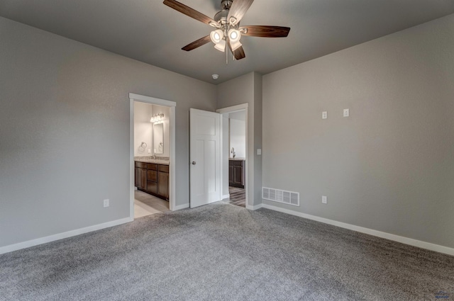 unfurnished bedroom with ensuite bathroom, ceiling fan, and light colored carpet