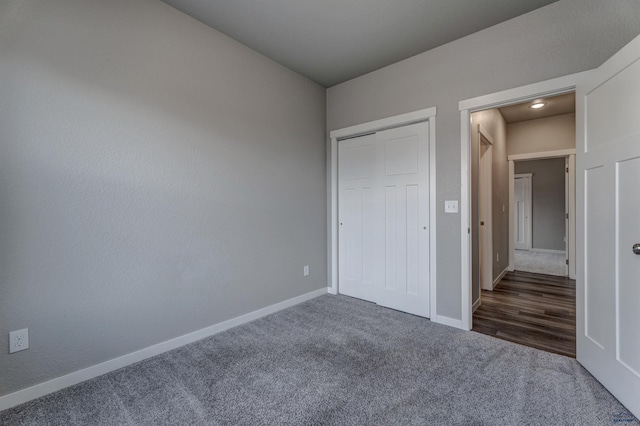 unfurnished bedroom featuring dark colored carpet and a closet