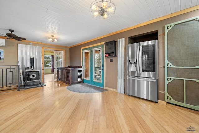 interior space featuring hardwood / wood-style flooring, stainless steel fridge with ice dispenser, wood ceiling, and a wood stove