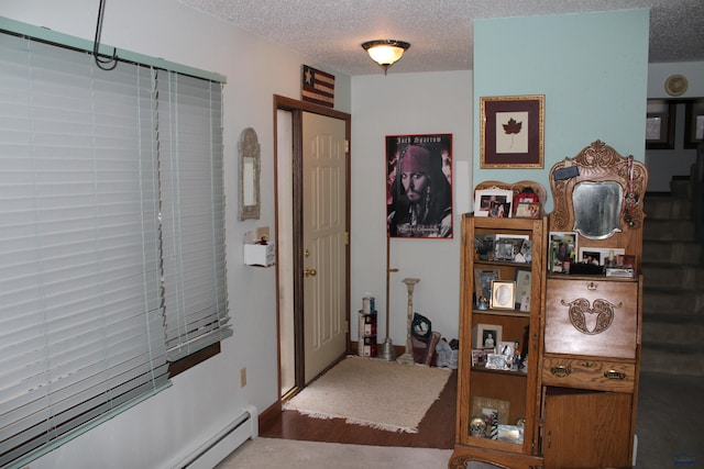 hallway featuring baseboard heating, carpet flooring, and a textured ceiling