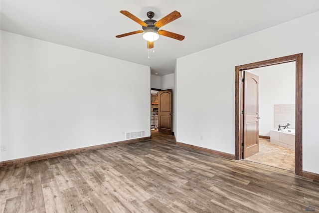 unfurnished bedroom with connected bathroom, ceiling fan, and hardwood / wood-style floors