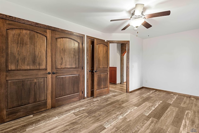 unfurnished bedroom with ceiling fan and light wood-type flooring