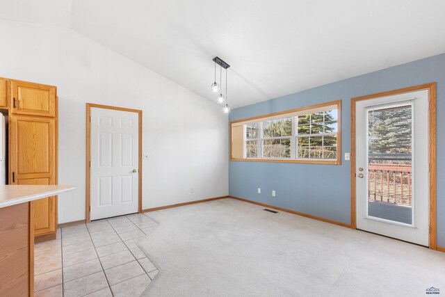 unfurnished dining area featuring light colored carpet and vaulted ceiling