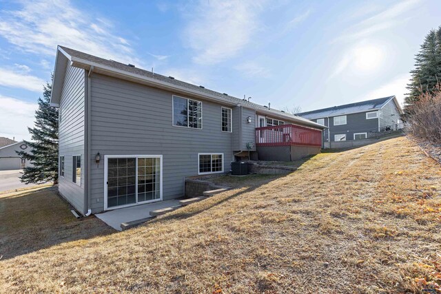 back of house with a yard, a wooden deck, and central air condition unit