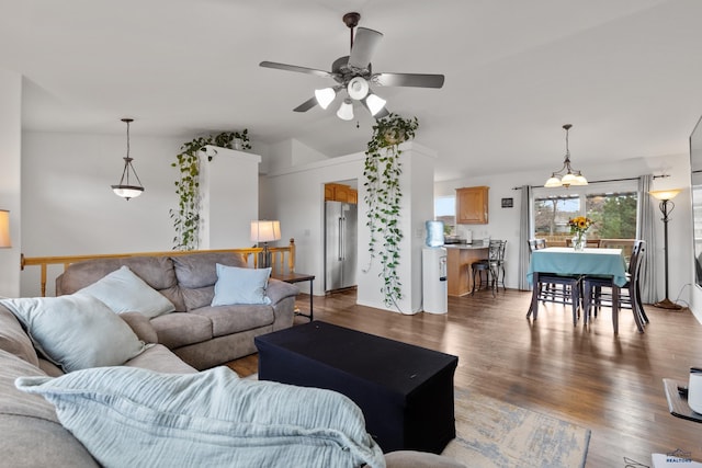 living room featuring dark hardwood / wood-style flooring, ceiling fan with notable chandelier, and lofted ceiling