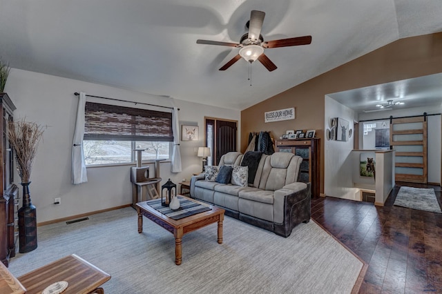 living room featuring hardwood / wood-style floors, ceiling fan, a barn door, and lofted ceiling