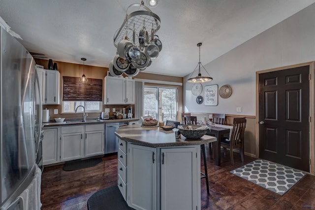 kitchen featuring a center island, hanging light fixtures, a breakfast bar, white cabinets, and appliances with stainless steel finishes