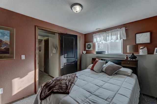 bedroom featuring carpet flooring and a textured ceiling