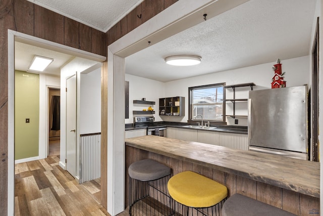 210 E Montana, Rapid City, SD 57701 - kitchen with a textured ceiling, stainless steel appliances, a sink, wooden counters, and light wood-type flooring
