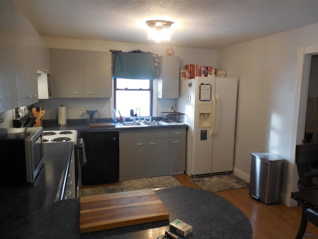 kitchen featuring gray cabinetry, range with electric cooktop, white fridge with ice dispenser, and sink