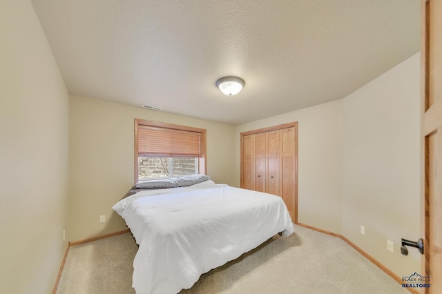 bedroom featuring a closet, carpet floors, and a textured ceiling