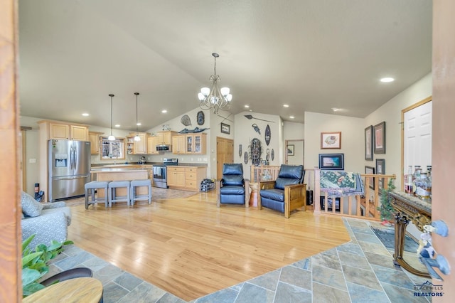 living room with a chandelier, lofted ceiling, and light wood-type flooring