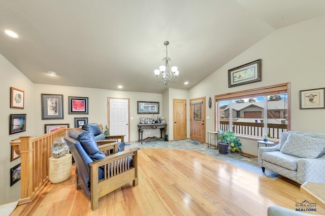 living room featuring light wood-type flooring, lofted ceiling, and an inviting chandelier