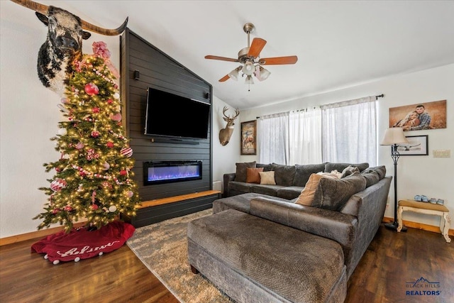 living room with ceiling fan, a large fireplace, dark hardwood / wood-style flooring, and lofted ceiling