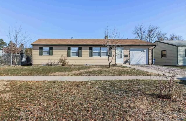 ranch-style home featuring a garage and a front lawn