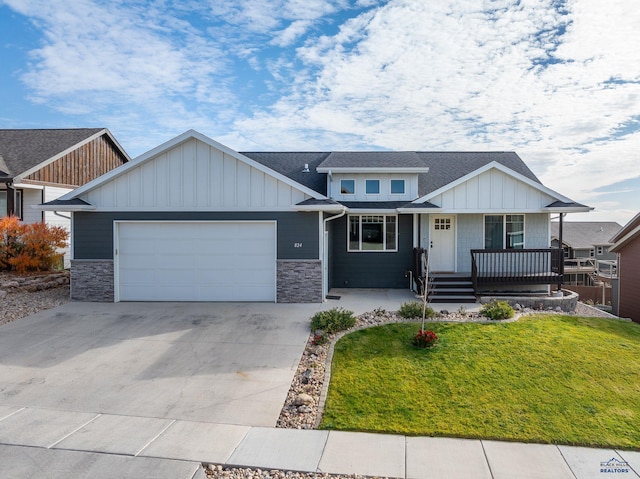 view of front of home with a front yard, a porch, and a garage