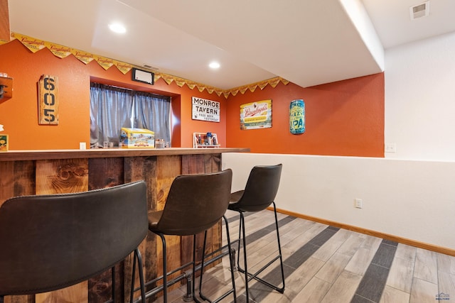 bar with hardwood / wood-style floors