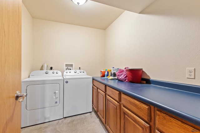 clothes washing area with washing machine and dryer and cabinets