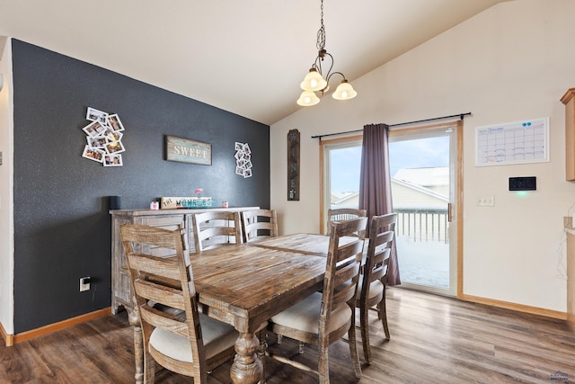 dining room with hardwood / wood-style floors, vaulted ceiling, and a notable chandelier