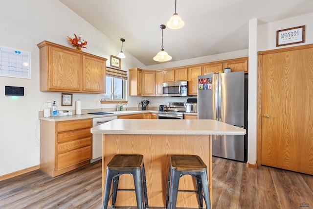 kitchen with lofted ceiling, stainless steel appliances, a kitchen island, and dark wood-type flooring