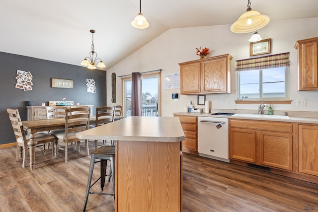 kitchen with dishwasher, a kitchen island, pendant lighting, and sink