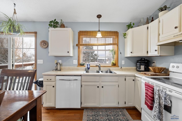 kitchen featuring sink, white cabinets, decorative light fixtures, and white appliances