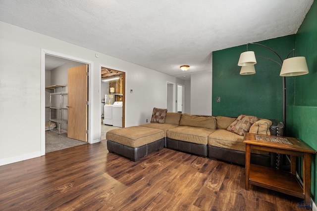 living room with washer and dryer, a textured ceiling, and dark hardwood / wood-style flooring