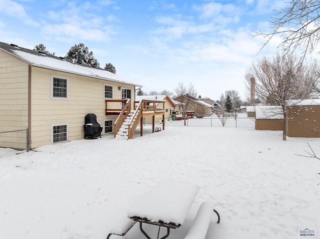 yard covered in snow with a deck