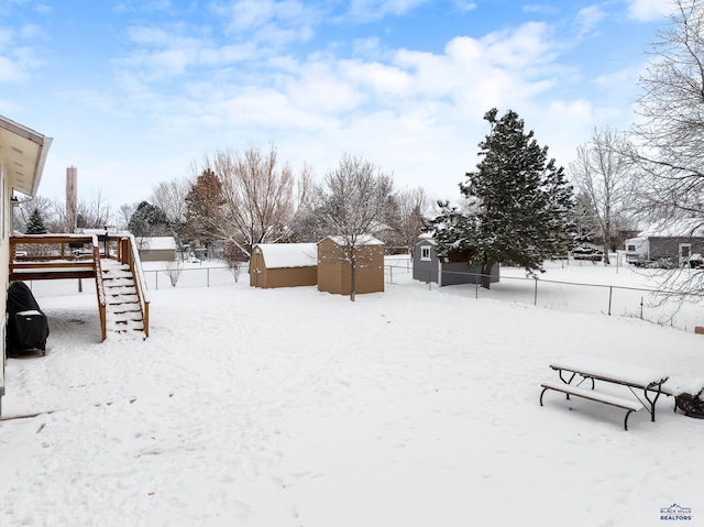 yard layered in snow with a storage unit