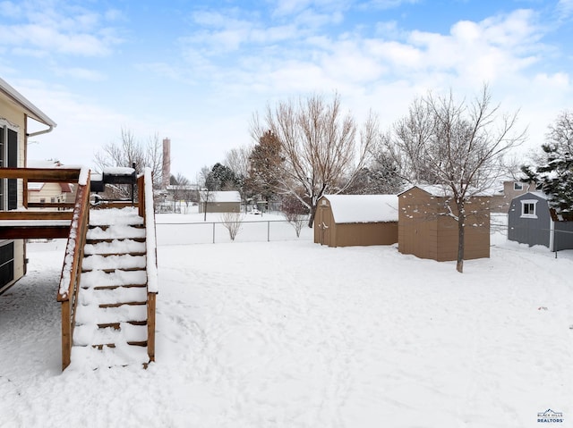 snowy yard with a storage shed