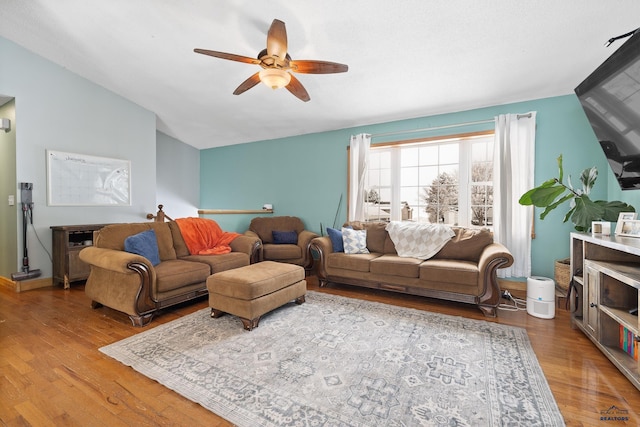 living room featuring ceiling fan, lofted ceiling, and light wood-type flooring