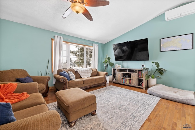 living room featuring hardwood / wood-style floors, ceiling fan, vaulted ceiling, and a wall mounted AC