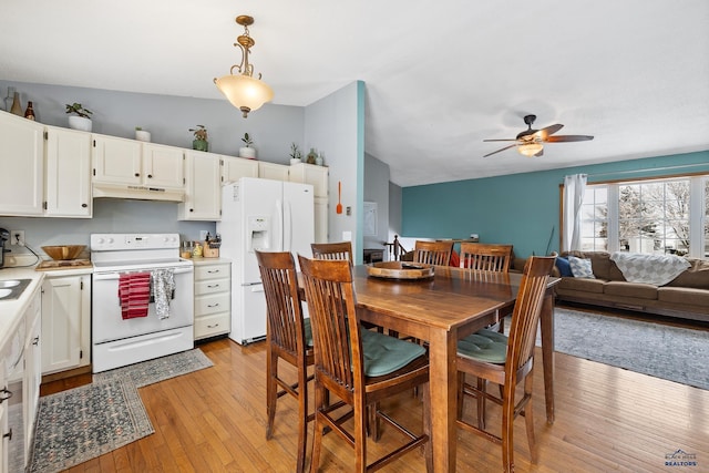 dining area featuring ceiling fan, vaulted ceiling, and light wood-type flooring