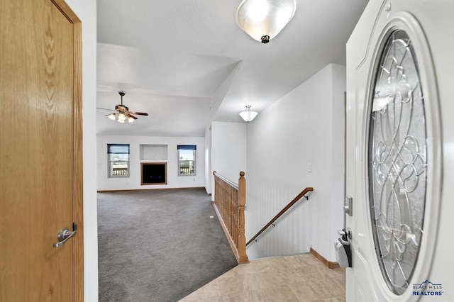 carpeted entryway with ceiling fan