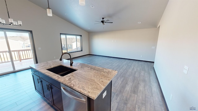 kitchen with dishwasher, sink, light stone counters, an island with sink, and pendant lighting