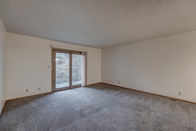 carpeted spare room featuring a textured ceiling