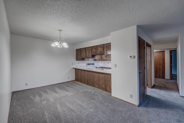 kitchen with kitchen peninsula, light carpet, decorative light fixtures, and a chandelier