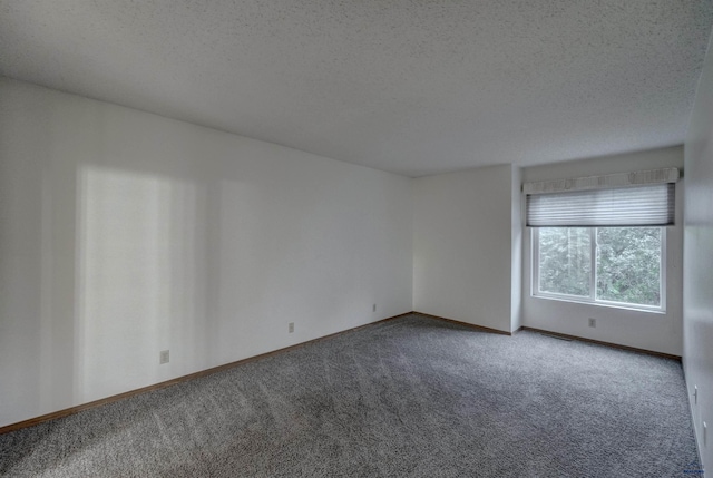 carpeted empty room featuring a textured ceiling