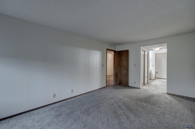 carpeted empty room featuring a textured ceiling