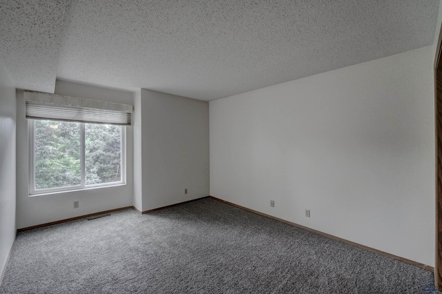 spare room featuring carpet floors and a textured ceiling